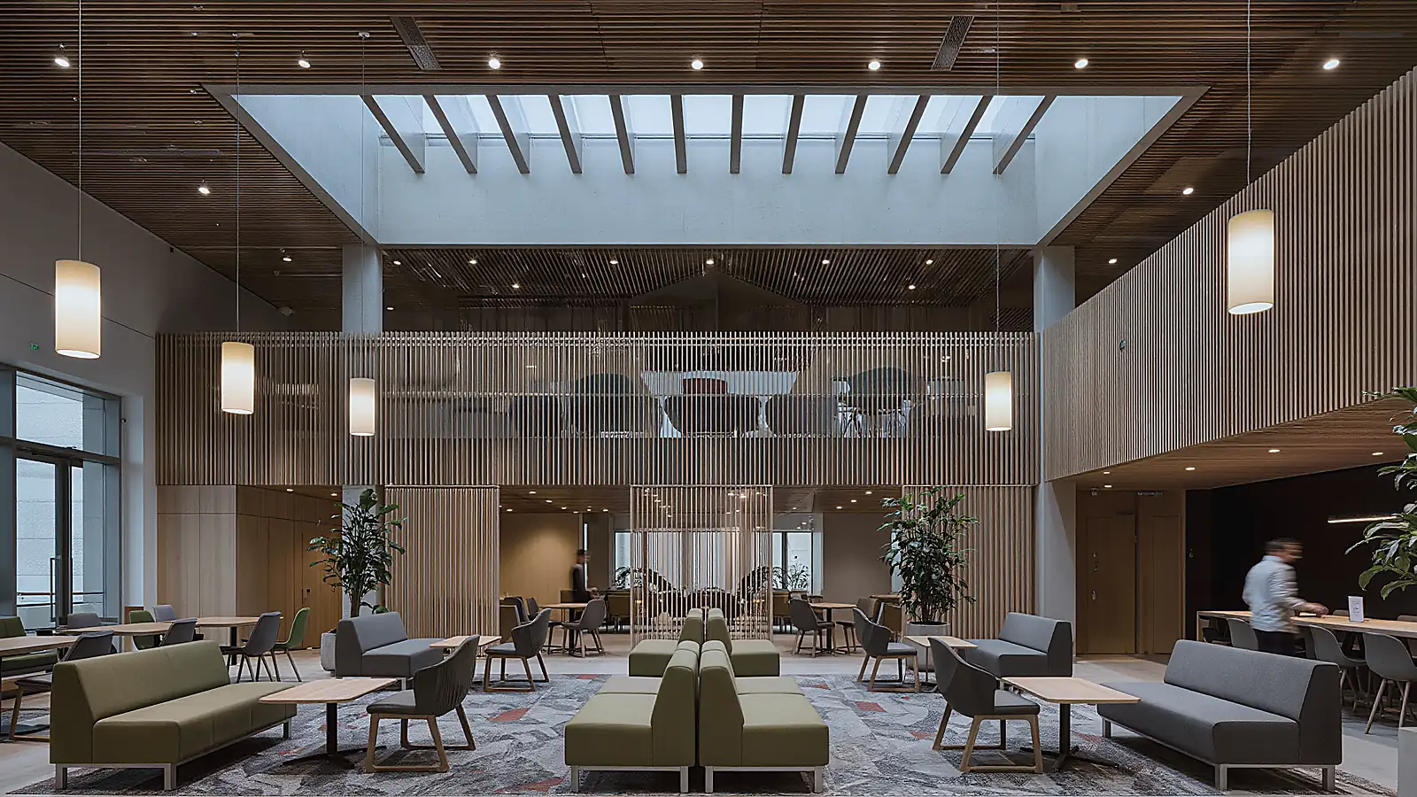 Atrium lounge with timber slat walls and a skylight above